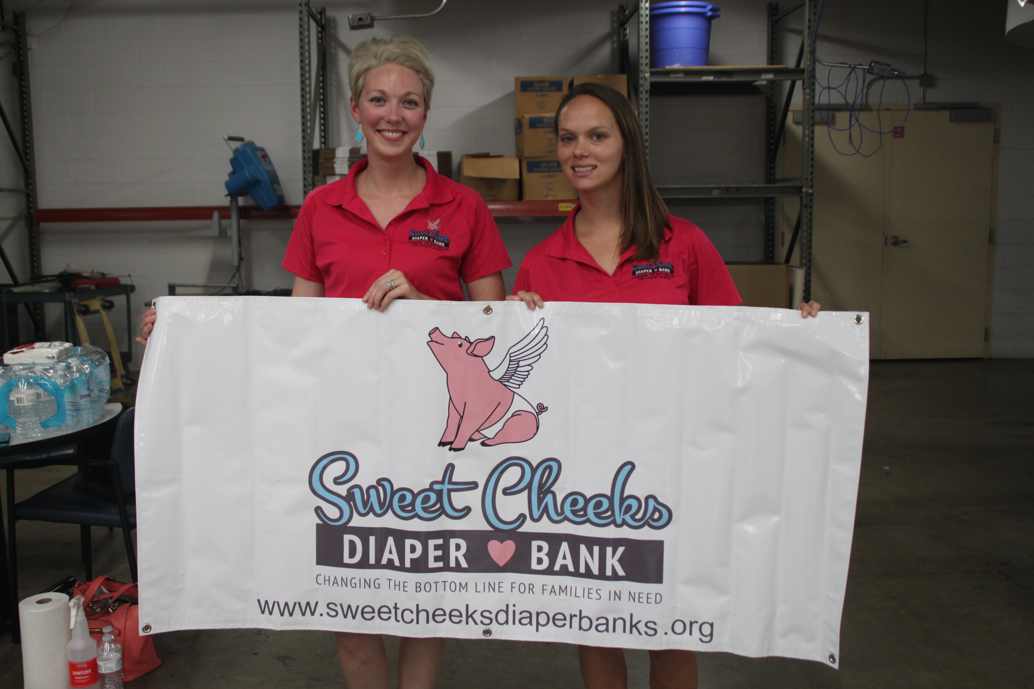 Megan Fischer, founder of Sweet Cheeks Diaper Bank, and Jamie Mack, volunteer coordinator, pose for a photo in the warehouse where they sort, package and distribute diapers to local partner agencies.